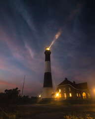 Beam of light from a lighthouse beacon. Dramatic cloudy foggy conditions - Fire Island New York