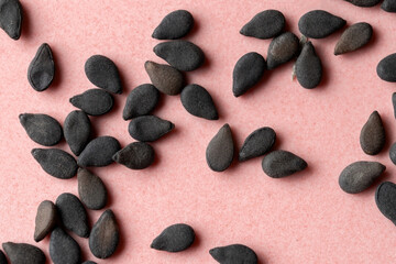 Black Sesame seeds isolated on pink background.
