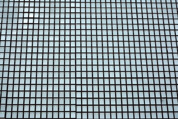 Facade texture of a glass mirrored office building. Fragment of the facade. Modern architecture of the office building.