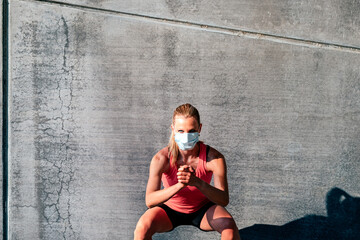 outdoor horizontal portrait of a fit healthy sporty woman with a protective mask