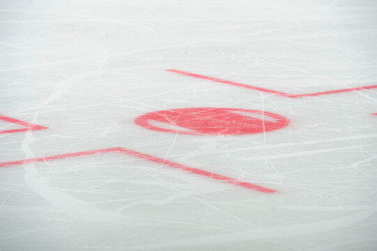 Close up of ice hockey rink markings and face-off spot.
