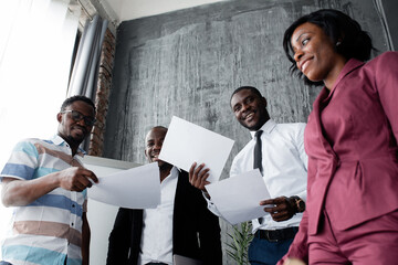 Bottom view of black colleagues scattering paper and smiling in honor of the suppression of racism...
