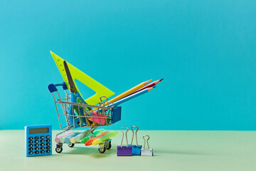 Trolley with stationery. Time to school shopping background. Welcome back to school concept, copy space. Time to study