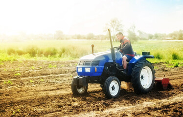 A farmer on a tractor works on the field. Cultivation technology equipment. Growing crops in a...