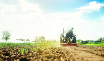 Farmer on a tractor with milling machine loosens, grinds and mixes soil. Loosening the surface,...