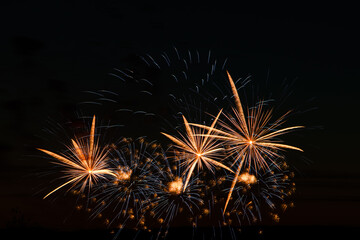 Festive fireworks in the night sky. Bright multi-colored salute on a black background. Place for text.