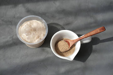 Bread starter and nutritional yeast in flakes. Sourdough making at home. Ingredients for homemade bread. Making dough for pizza or bread. Rising active yeast. 