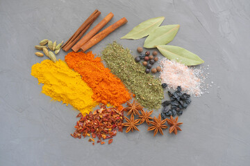 Asian spices and herbs on grey background. Indian spices of different colors, bright advertising...