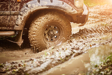 moving dirty off-road car tire in mud close-up