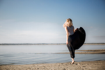 A young woman is dancing on the lake, laughing and smiling, she has a great mood and a sporty...