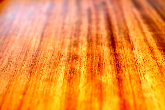 Perspective view of a hardwood surface finish in natural oil. Oiled wood finish in warm light, selective view, close up.