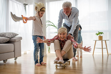 Grandchildren and grandparents having fun at home while playing together at home