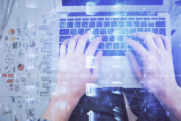Multi exposure of man's hands typing over computer keyboard and data theme hologram drawing. Top view. Technology concept.