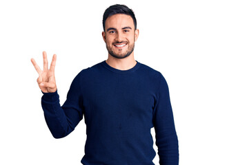 Young handsome man wearing casual clothes showing and pointing up with fingers number three while smiling confident and happy.