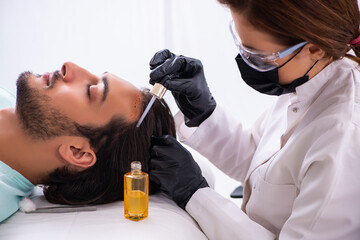 Young man visiting female beautician in hair transplantation con