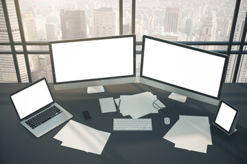 Top view of coworking designer desktop with two computer screen, laptop, tablet and city view.