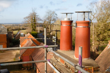 Clay chimney pot with cowl on a roof in UK