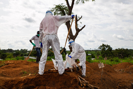 Lunsar, Sierra Leone - June 24, 2015: members of the burial team bury an ebola dead person in the main cemetery during pandemic. Ebola context