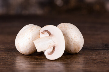 Sliced fresh champignon mushroom on a wooden table.