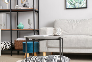 Stylish sofa, table and rack in interior of living in room