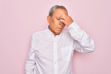 Obraz premium Senior handsome grey-haired man wearing elegant shirt over isolated pink background tired rubbing nose and eyes feeling fatigue and headache. Stress and frustration concept.