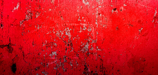Cracked and peeling red oxidized paint on wood with texture and grunge finish
