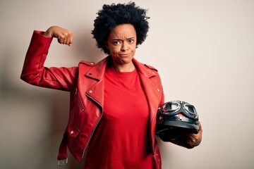 Young African American afro motorcyclist woman with curly hair holding motorcycle helmet Strong...
