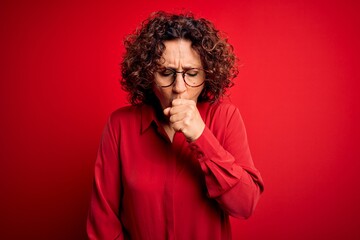 Fototapeta na wymiar Middle age beautiful curly hair woman wearing casual shirt and glasses over red background feeling unwell and coughing as symptom for cold or bronchitis. Health care concept.