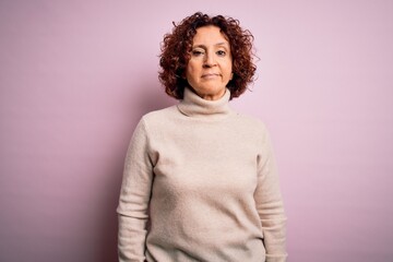 Obraz premium Middle age beautiful curly hair woman wearing casual turtleneck sweater over pink background looking sleepy and tired, exhausted for fatigue and hangover, lazy eyes in the morning.