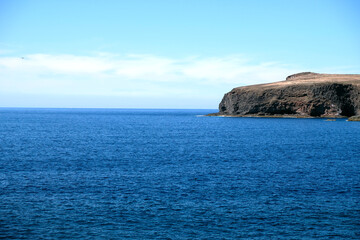 Fototapeta na wymiar Rocky headland and ocean. Pronounced cape, Gran Canaria, Canary Islands, Spain, Africa. Large empty copy space.