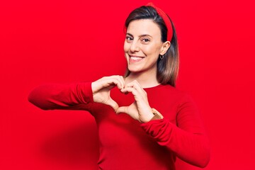Young beautiful woman wearing casual clothes smiling in love doing heart symbol shape with hands. romantic concept.