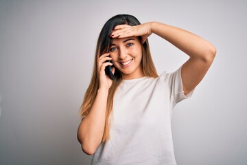 Young beautiful brunette woman having conversation talking on the smartphone stressed with hand on head, shocked with shame and surprise face, angry and frustrated. Fear and upset for mistake.