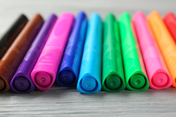 Colorful markers on wooden background, closeup