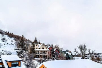 Overcast sky over residential neighborhood on snow covered slope of a hill