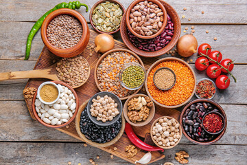 Different raw legumes with spices on table