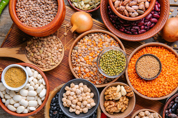 Different raw legumes with spices on table