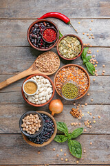 Different raw legumes with spices on table