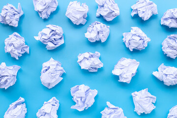 White crumpled paper balls on a blue background.