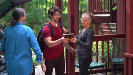 Young man moving out of house leaving for college packing luggage in car hugging parents goodbye mother and father embracing son farewell 4k footage