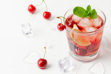 refreshing red cocktail with sparkling water and ice garnished with a lime and cherry