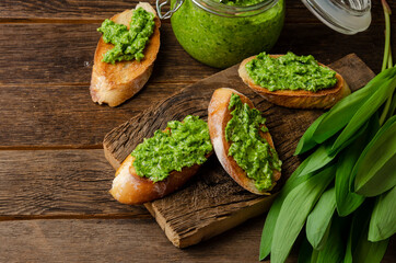 fresh ramson wild garlic pesto on white background with toasts