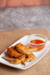Place the fried chicken paired with chili sauce on a white plate.
