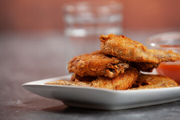 Place the fried chicken paired with chili sauce on a white plate.

