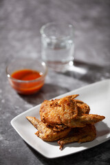 Place the fried chicken paired with chili sauce on a white plate.
