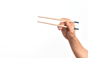 Hand of caucasian young man holding chopsticks over isolated white background