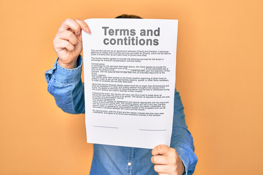 Woman holding terms and conditions document paper standing over isolated yellow background