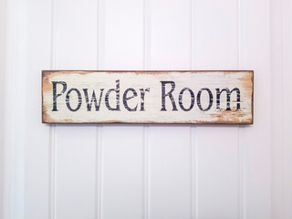 Rustic rectangular wooden Powder Room sign against white panelled door