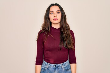 Young beautiful woman wearing casual t-shirt standing over isolated white background with serious expression on face. Simple and natural looking at the camera.