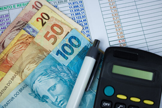 Brazilian money with calculator and numerical chart background
