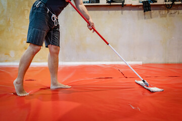 Unknown caucasian man cleaning tatami mats at MMA or BJJ or Judo wrestling martial arts gym using...
